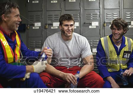 Workers sitting in locker room View Large Photo Image Stock Image - Workers sitting in locker room. Fotosearch