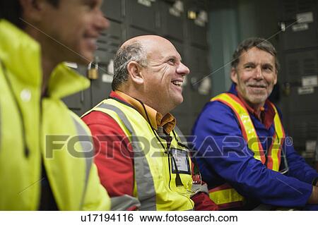 Workers sitting in locker room View Large Photo Image Stock Photograph - Workers sitting in locker room. Fotosearch