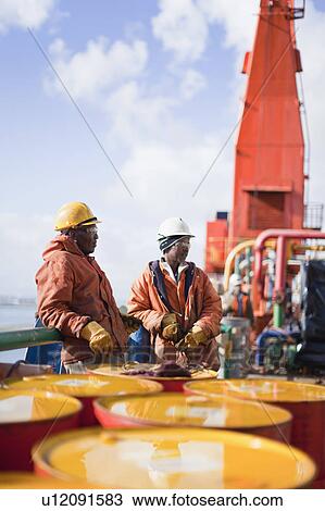 Workers standing on oil rig View Large Photo Image Stock Image - Workers standing on oil rig. Fotosearch