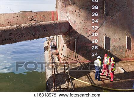 Stock Photography - Workers standing on oil rig. Fotosearch