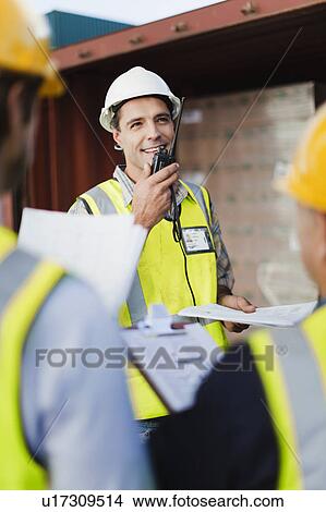 Picture - Workers talking in shipping yard. Fotosearch