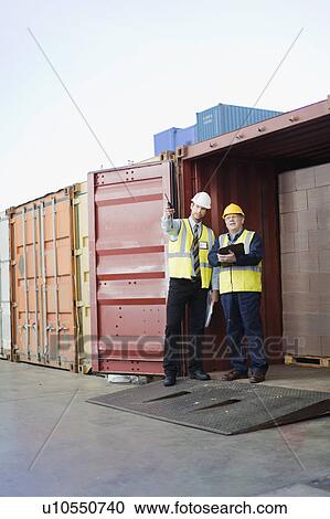 Workers talking in shipping yard View Large Photo Image Stock Image - Workers talking in shipping yard. Fotosearch