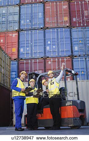 Stock Photo - Workers talking in shipping yard. Fotosearch