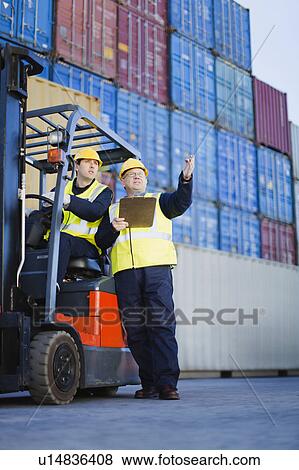 Workers talking in shipping yard View Large Photo Image Stock Photo - Workers talking in shipping yard. Fotosearch