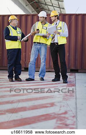 Workers talking in shipping yard View Large Photo Image Stock Photo - Workers talking in shipping yard. Fotosearch