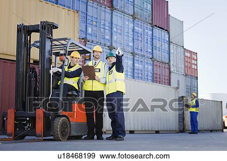 Workers talking in shipping yard View Large Photo Image Stock Photo - Workers talking in shipping yard. Fotosearch