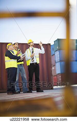Stock Photo - Workers talking in shipping yard. Fotosearch