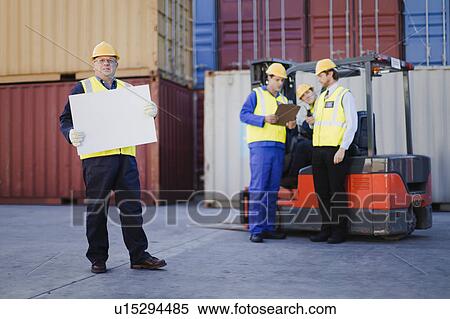Workers talking in shipping yard View Large Photo Image Stock Photography - Workers talking in shipping yard. Fotosearch