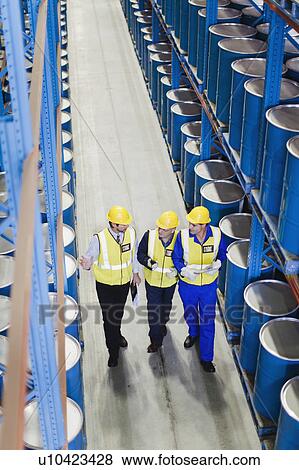 Stock Photo - Workers talking in warehouse. Fotosearch
