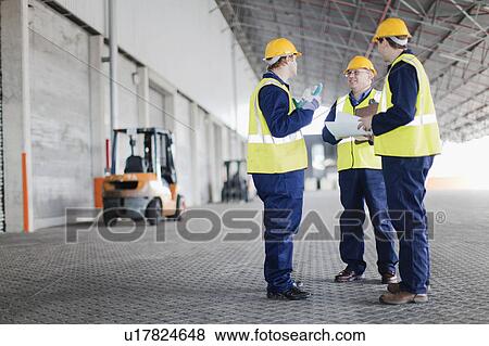 Workers talking in warehouse View Large Photo Image Stock Photo - Workers talking in warehouse. Fotosearch