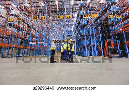 Workers talking in warehouse View Large Photo Image Stock Photo - Workers talking in warehouse. Fotosearch