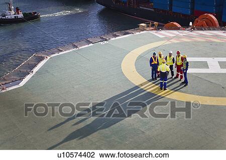 Workers talking on helipad of oil rig View Large Photo Image Stock Image - Workers talking on helipad of oil rig. Fotosearch