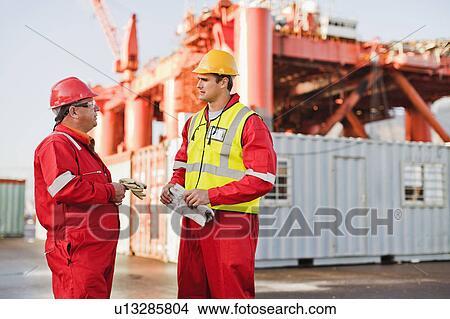 Workers talking on oil rig View Large Photo Image Picture - Workers talking on oil rig. Fotosearch