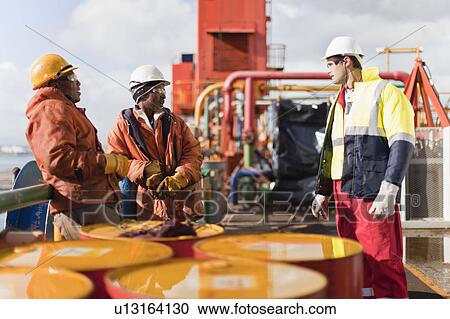 Workers talking on oil rig View Large Photo Image Stock Image - Workers talking on oil rig. Fotosearch