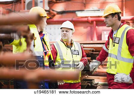 Workers talking on oil rig View Large Photo Image Stock Image - Workers talking on oil rig. Fotosearch
