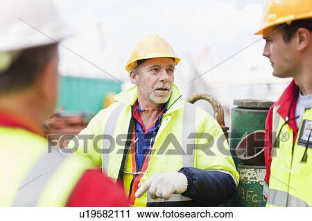 Workers talking on oil rig View Large Photo Image Stock Image - Workers talking on oil rig. Fotosearch