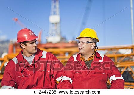Stock Photo - Workers talking on oil rig. Fotosearch