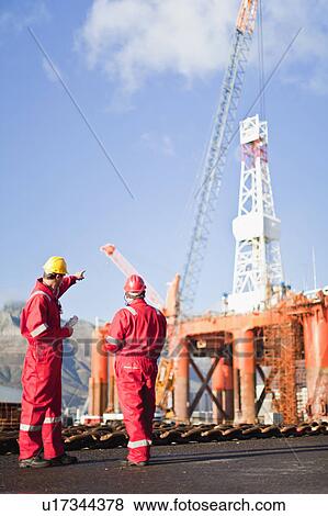 Workers talking on oil rig View Large Photo Image Stock Photo - Workers talking on oil rig. Fotosearch