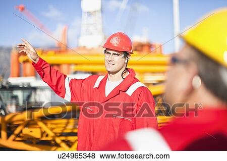 Workers talking on oil rig View Large Photo Image Stock Photo - Workers talking on oil rig. Fotosearch
