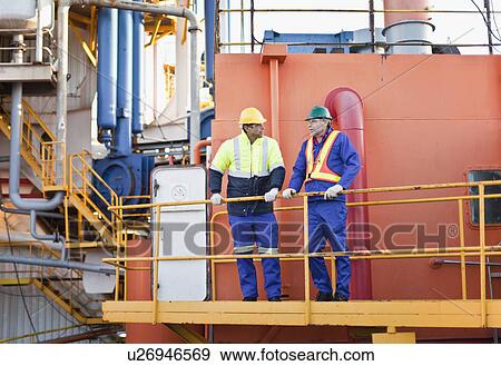 Stock Photo - Workers talking on oil rig. Fotosearch
