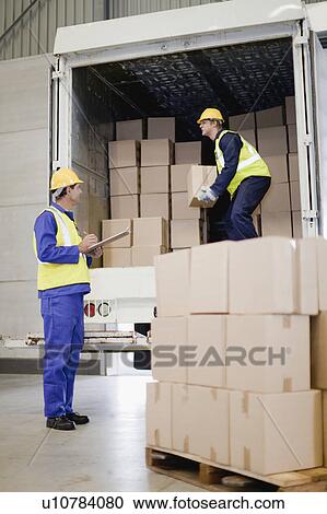 Stock Image - Workers unloading boxes from truck. Fotosearch