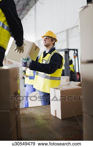 Stock Photo - Workers unloading boxes from truck. Fotosearch
