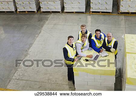 Picture - Workers using laptop in warehouse. Fotosearch