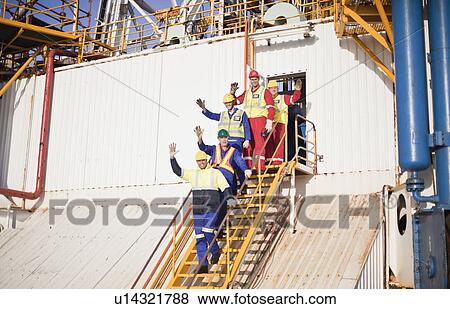 Stock Photo - Workers waving from steps of oil rig. Fotosearch