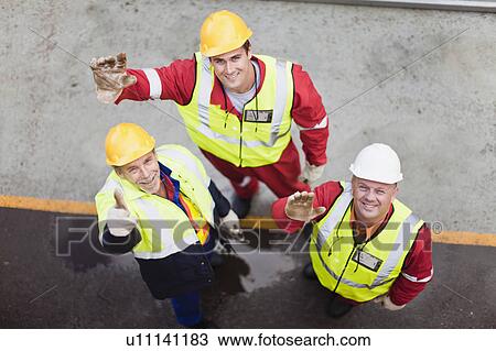 Stock Image - Workers waving on oil rig. Fotosearch