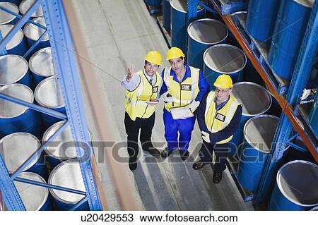 Stock Image - Workers with clipboards in warehouse. Fotosearch