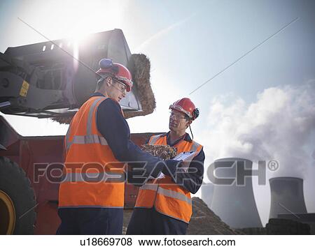 Stock Photo - Workers with elephant grass biomass fuel. Fotosearch