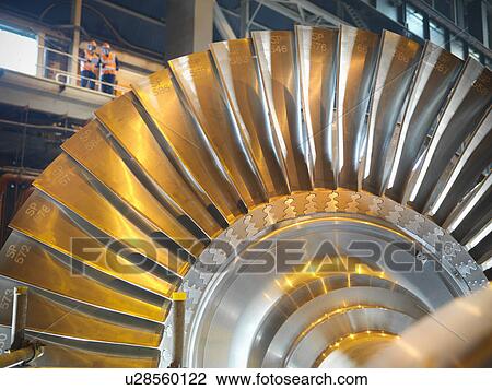 Stock Image - Workers with turbine in power station. Fotosearch