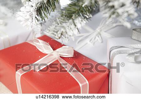 Stock Photo - Wrapped gifts under Christmas tree. Fotosearch