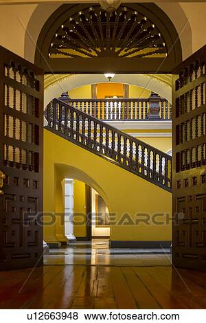 Archbishops' palace: Interior detail of groundfloor mahogany doorway, staircase and balustrade with yellow stucco walls: Spanish Colonial style, Lima, Peru View Large Photo Image Stock Photo - Archbishops' palace: Interior detail of groundfloor mahogany doorway, staircase and balustrade with yellow stucco walls: Spanish Colonial style, Lima, Peru. Fotosearch