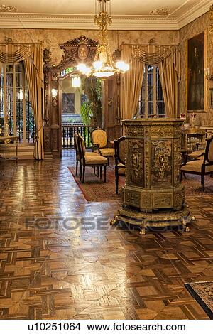 Picture - Casa Aliaga interior, drawing room with ornate mahogany doorway, stucco ceiling, intarsia wooden flooring, and gilt stove, paintings from Spanish Baroque era, Lima, Peru. Fotosearch