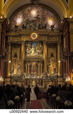 Stock Image - Chapel of the Catedral with wedding in progress, ornate gilded decor of Spanish Baroque era, Lima, Peru. Fotosearch