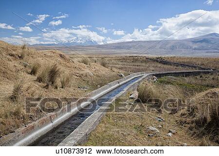 Cordilleras mountains: irrigation system with water channel snaking across grassy hillside, with snow-capped mountains beyond, Peru View Large Photo Image Stock Image - Cordilleras mountains: irrigation system with water channel snaking across grassy hillside, with snow-capped mountains beyond, Peru. Fotosearch