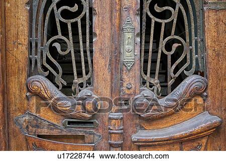 Picture - Door: detail of Spanish colonial wooden door with ornate bronze decoration, pastel green walls with graffiti, Lima, Peru. Fotosearch