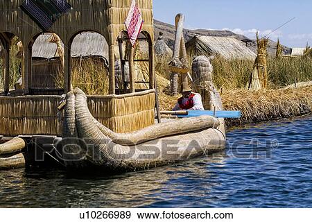 Lake Titicaca: islands of Uros with man in traditional costume in reed boat, reed huts and island beside, Peru View Large Photo Image Stock Photo - Lake Titicaca: islands of Uros with man in traditional costume in reed boat, reed huts and island beside, Peru. Fotosearch