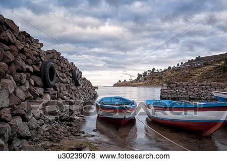Lake Titicaca: Llachon peninsula, two fishing boats moored at sunrise, in harbour inlet, Peru View Large Photo Image Stock Photo - Lake Titicaca: Llachon peninsula, two fishing boats moored at sunrise, in harbour inlet, Peru. Fotosearch