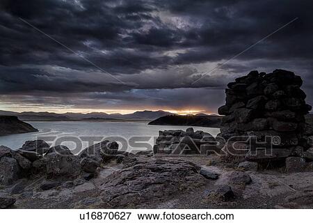 Lake Titicaca: Sillustani funerary towers with view across Lake Umaya at sunset, dramatic storm clouds and light, Peru View Large Photo Image Stock Photo - Lake Titicaca: Sillustani funerary towers with view across Lake Umaya at sunset, dramatic storm clouds and light, Peru. Fotosearch
