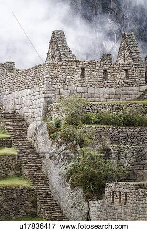 Machu Picchu Inca ruins: detail of agricultural sector terraces and buildings with steep mountain wall beyond in mist, Machu Picchu, Sacred Valley, Peru View Large Photo Image Stock Photo - Machu Picchu Inca ruins: detail of agricultural sector terraces and buildings with steep mountain wall beyond in mist, Machu Picchu, Sacred Valley, Peru. Fotosearch
