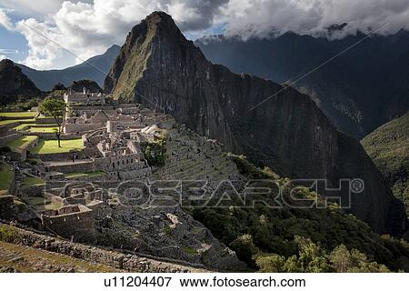 Stock Photo - Machu Picchu Inca ruins: view of Eastern Urban sector with Huayna Picchu mountain in evening sunlight after storm, Machu Picchu, Sacred Valley, Peru. Fotosearch