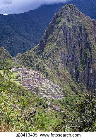Stock Photography - Machu Picchu Inca ruins: view of Eastern Urban sector with Huayna Picchu beyond, as seen from Sun Gate trail afternoon sunlight after storm, Machu Picchu, Sacred Valley, Peru. Fotosearch