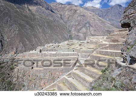 Stock Photography - Ollantaytambo: stone stairway and agricultural terracing of Inca citadel,, flanked by mountains of Sacred valley, sunny early morning, Ollantaytambo, Sacred Valley, Cuzco, Peru. Fotosearch