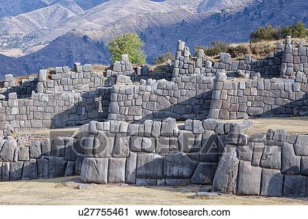 Stock Image - Sacsaywaman Inca ruins: view of the massive zig zag stone wall fortifications in late afternoon sunlight, with strong triangular shadows, Sacred Valley, Cuzco, Peru. Fotosearch