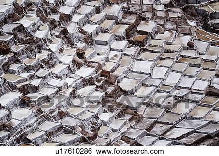 Stock Photograph - Salinas salt pans, aerial view detail of terraced rectangular pans filled with concentrated saline to evaporate, Sacred Valley, Peru. Fotosearch