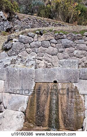 Stock Photograph - Tambomachay: view of ceremonial Inca stone baths with running fountain in hewn rock, Sacred Valley, Cuzco, Peru. Fotosearch