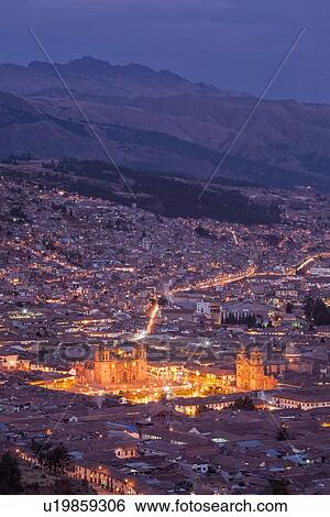 Twilight view of Cuzco night lights: Plaza de Armas with Iglesia de la Compania on right,, and Catedral to left, as seen across red tiled rooftops from Pukin, mountains beyond, Cuzco, Peru View Large Photo Image Stock Photograph - Twilight view of Cuzco night lights: Plaza de Armas with Iglesia de la Compania on right,, and Catedral to left, as seen across red tiled rooftops from Pukin, mountains beyond, Cuzco, Peru. Fotosearch