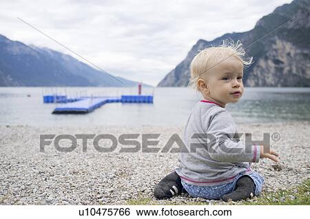 Baby playing on rocky beach View Large Photo Image Stock Photograph - Baby playing on rocky beach. Fotosearch